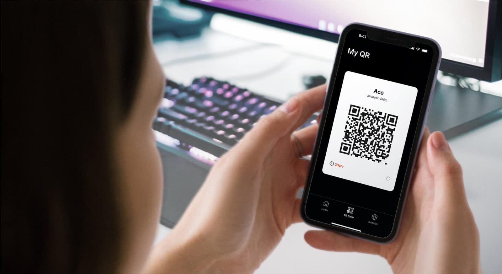 A player holding a phone showing their PlayID rotating QR code